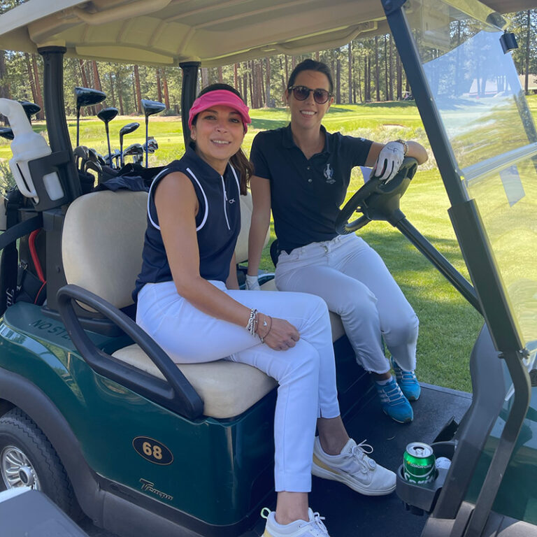 2 women golfers in a cart